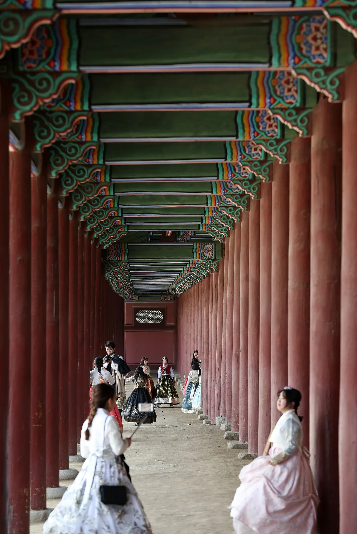 Visitors in rented hanbok in a palace courtyard in Seoul, South Korea